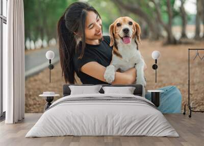 Happy asian woman playing with dog together in public park outdoors, Friendship between human and their pet Wall mural