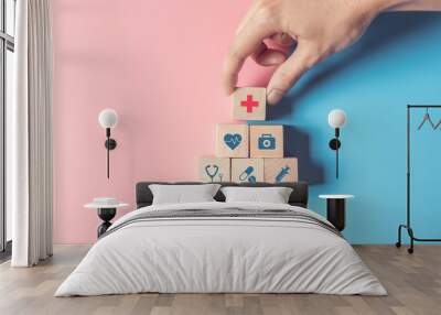 Health Insurance Concept, Hand of man arranging wood cube stacking with icon healthcare medical on pastel blue and pink background, copy space. Wall mural