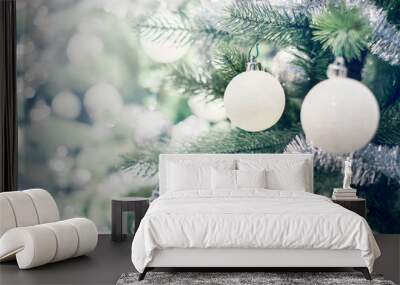 Silver and white bauble hanging from a decorated Christmas tree with bokeh and snow, copy space. Xmas holiday background. Wall mural