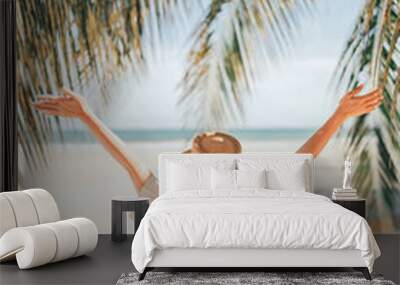 Summer beach vacation concept, Happy woman with hat relaxing at the seaside and looking away, in the summer against a backdrop of palm trees and sea beach. Wall mural