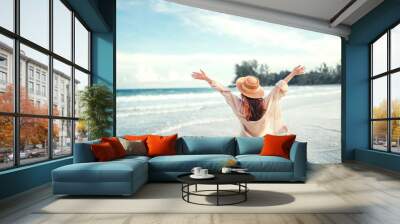 summer beach vacation concept, young woman with hat relaxing with her arms raised to her head enjoyi Wall mural