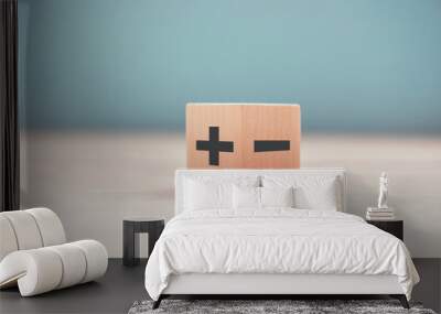 The concept of opposites, wood blog with plus and minus on blue background, flat lay, copy space. Wall mural