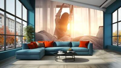 Woman stretching hands in bed after wake up in the morning, Concept of a new day and joyful weekend. Wall mural