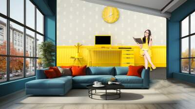 business woman sitting at the desk yellow color Wall mural