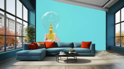 Hand holding light bulb yellow pastel color on blue background Wall mural