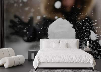 The girl throws a snowball at the camera. The snowball shatters into snowflakes Wall mural