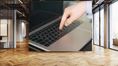 One single finger pressing keyboard button in laptop with blurry background. Ordering or choosing concept Wall mural