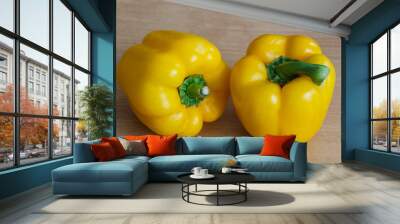 Two whole yellow peppers on a table Wall mural