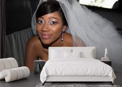 Beautiful young black bride looks at the camera and smiles in wedding car Wall mural