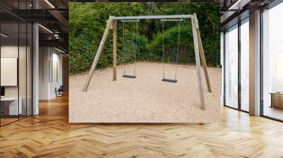 Empty chain swings wooden balance for children in garden park Wall mural