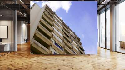 Facade of a modern height apartment building on a sunny day with a blue cloud sky Wall mural