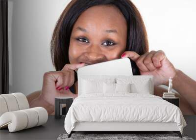 Young african american woman showing smartphone blank screen over mouth in isolated background Wall mural