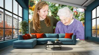 Elderly woman and young carer Wall mural