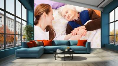 young doctor holds the elderly woman hands Wall mural