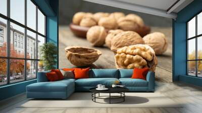 Walnuts over a wooden table and on a plate Wall mural