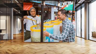 a pretty girl in a veil sells es campur using a scoop to get coconut milk from a jar on a cart Wall mural