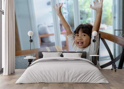 asian beautiful toddler girl having breakfast by herself in the morning at dining room Wall mural