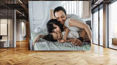 Asian happy family and child daughter relaxing on the bed enjoy holiday Wall mural