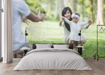 baby learn to walk with their parent in the park Wall mural