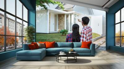 back portrait of young couple standing in front of their new house Wall mural