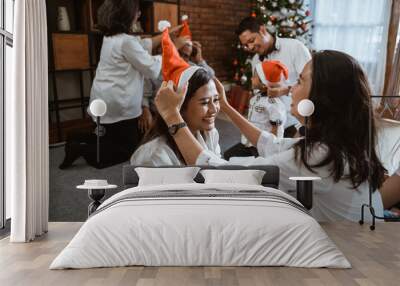 big family put santa hat during christmas gathering together Wall mural