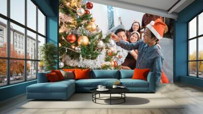 boy happy decorating christmas tree at home with family Wall mural