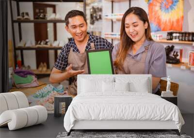 Couple asian workers sitting holding tablet with mockup screen Wall mural