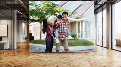 father piggyback ride with his son in front of the house playing enjoying their time in the morning Wall mural