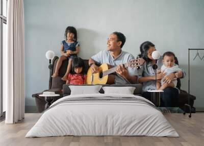 father played the guitar to fill the activities while staying at home, mother and son sang along happily Wall mural