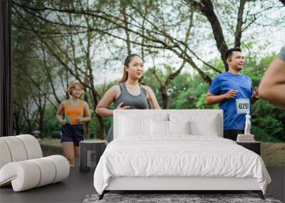 fit asian woman running on marathon event wearing sportswear Wall mural