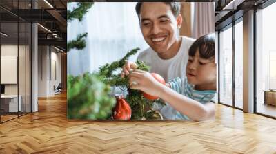 happy asian dad and girl decorating christmas tree together Wall mural