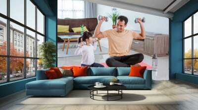 happy father and daughter exercising doing dumbbell lifting together in the livingroom Wall mural