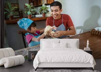 Joyful father and daughter cooking homemade pastry in the kitchen Wall mural