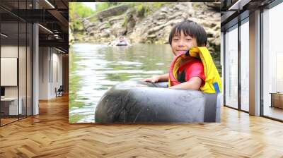 kid on inflatable tube Wall mural