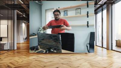 portrait of asian young man fix a problem with keyboard of personal computer in office room Wall mural