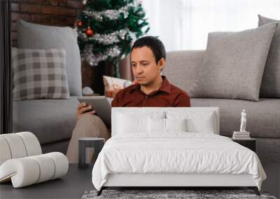 portrait of serious asian young man sitting on floor front of co Wall mural