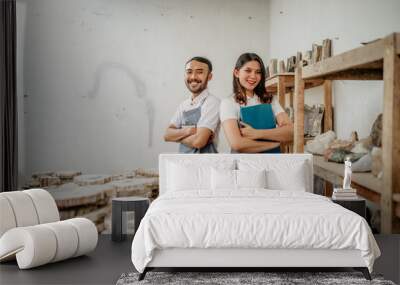 smiling young man and young woman stone craft entrepreneurs with arms crossed in a craft shop Wall mural