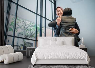 Success muslim businesswomen hugging each other inside office building Wall mural