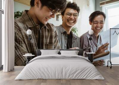 three young asian worker chatting about their product at work Wall mural