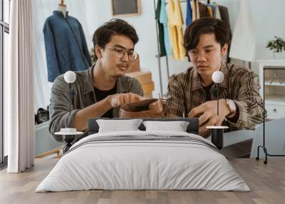 Two young asian businessman chatting about their product in the office Wall mural