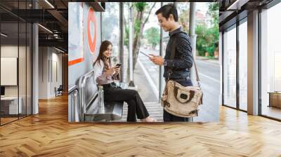 worker busy using their gadget while waiting for public transport Wall mural