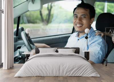 young asian driver smile to the camera when drive a car Wall mural