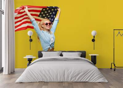 American girl. Happy young woman in denim clothes holding USA flag isolated on yellow background. Banner. Copy space for text Wall mural