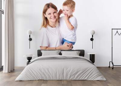 Beautiful smimling young mother with her toddler son (real family). Isolated on white background.  Wall mural