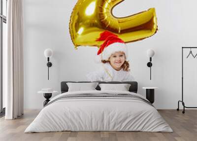 Double benefit. Portrait of little child girl in Santa hat posing with gold 2 two number shape balloon isolated over white background. Christmas, new year and Birthday party. Wall mural