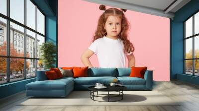 Portrait of cute european little toddler girl over pink background. Looking at camera. Child model in white T-shirt. Advertising childrens products Wall mural