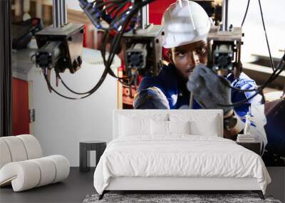 African engineer or worker checking and fixing machine in robot factory Wall mural