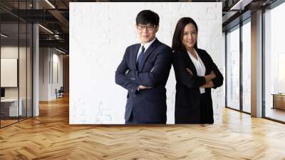 businessman and businesswoman in formal suit, standing back to back together in office Wall mural