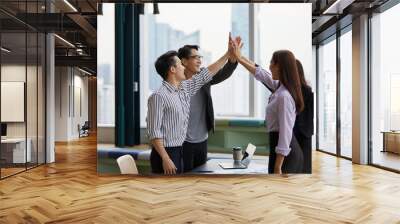 businesspeople giving high five pose and celebrating success at work in the office Wall mural