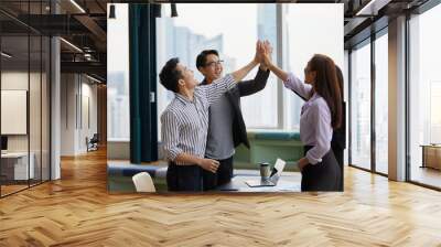 businesspeople giving high five pose and celebrating success at work in the office Wall mural